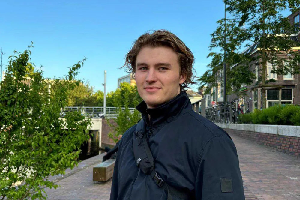 employee stands in an open area looking at the camera